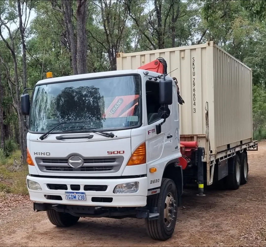 Hino crane truck carrying a shipping container